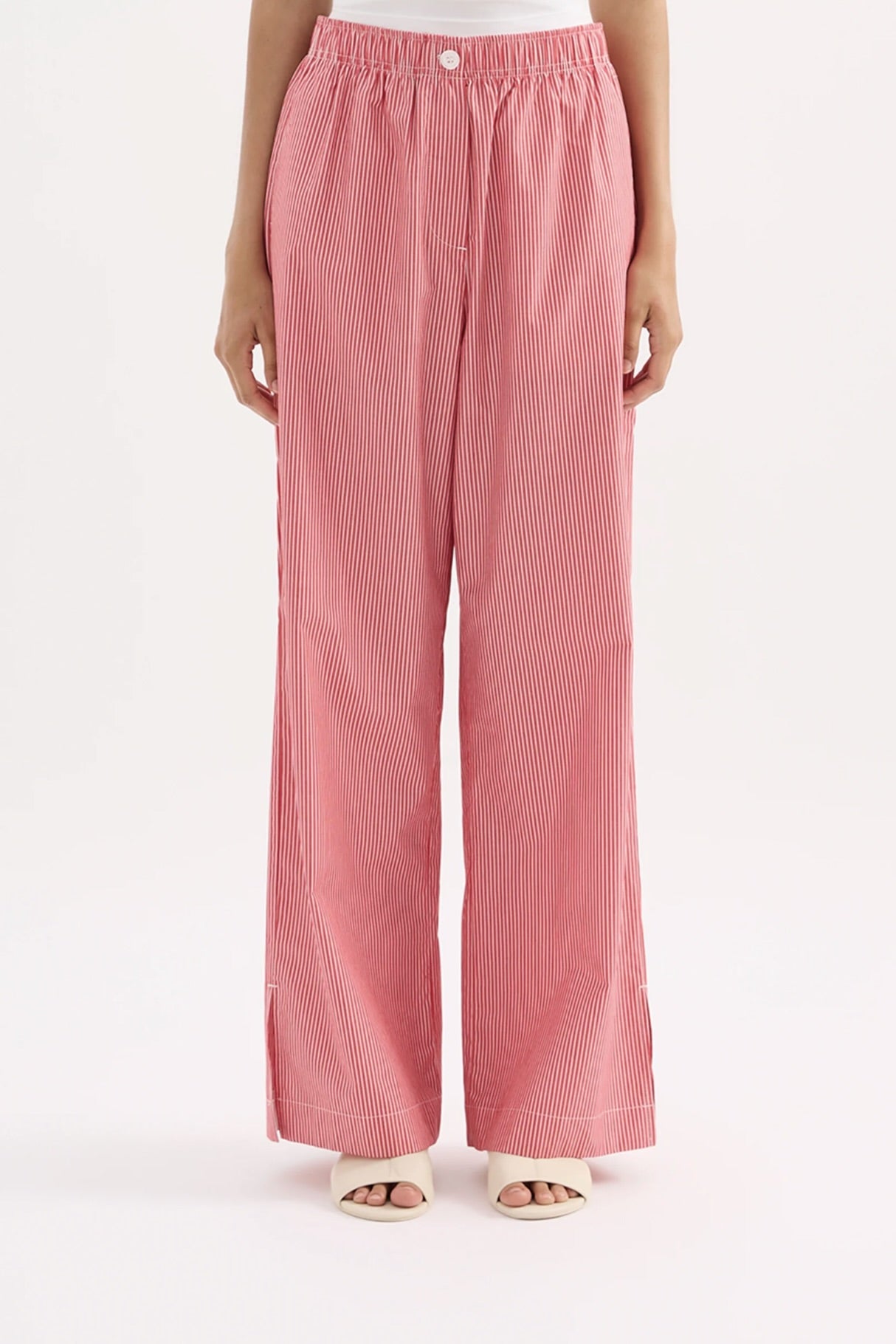 Pink ribbed pants worn by a person on a white background